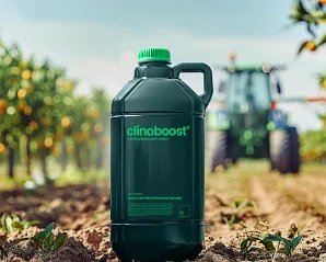 A one-litre Clinoboost container in an orchard, a tractor behind